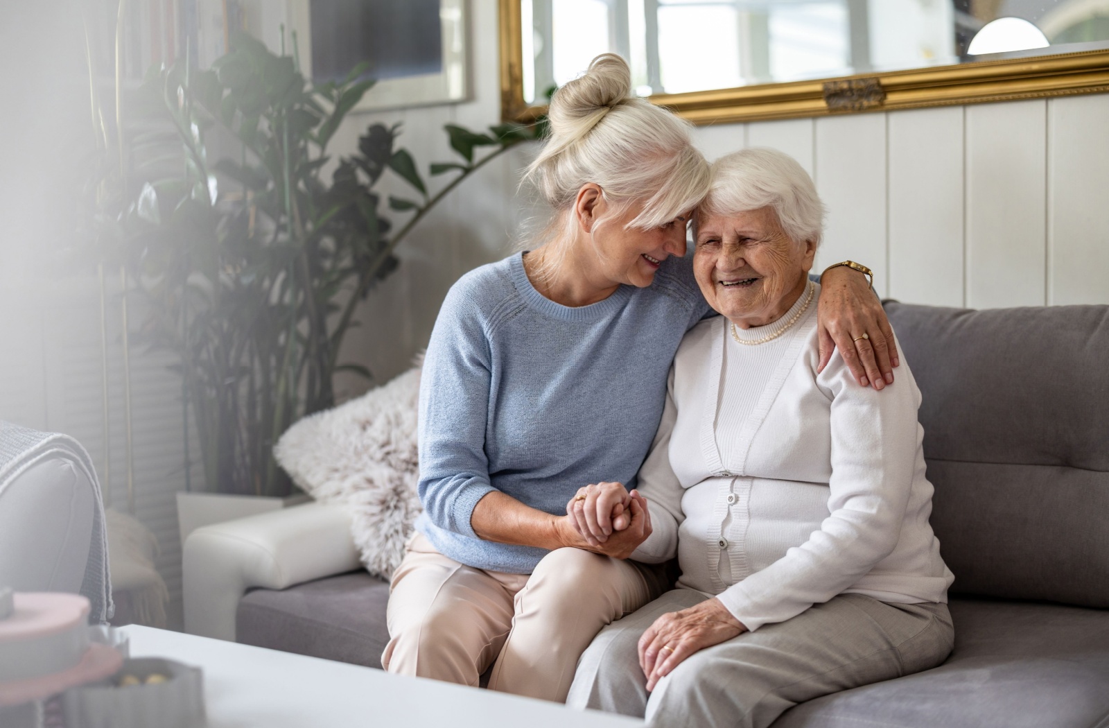 An adult holding their parent with dementia lovingly.