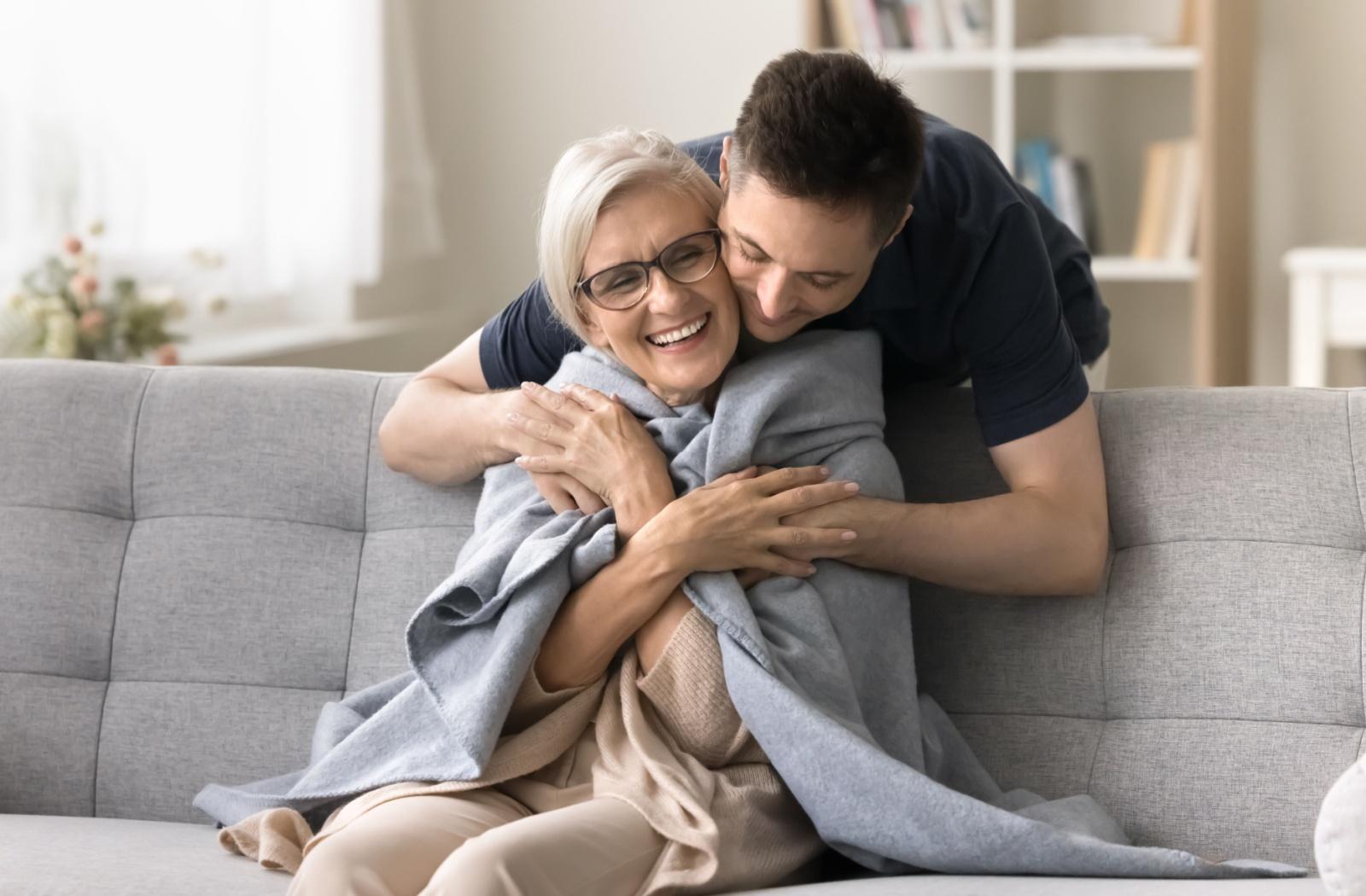 A family member lovingly hugs their loved one from behind, offering support.
